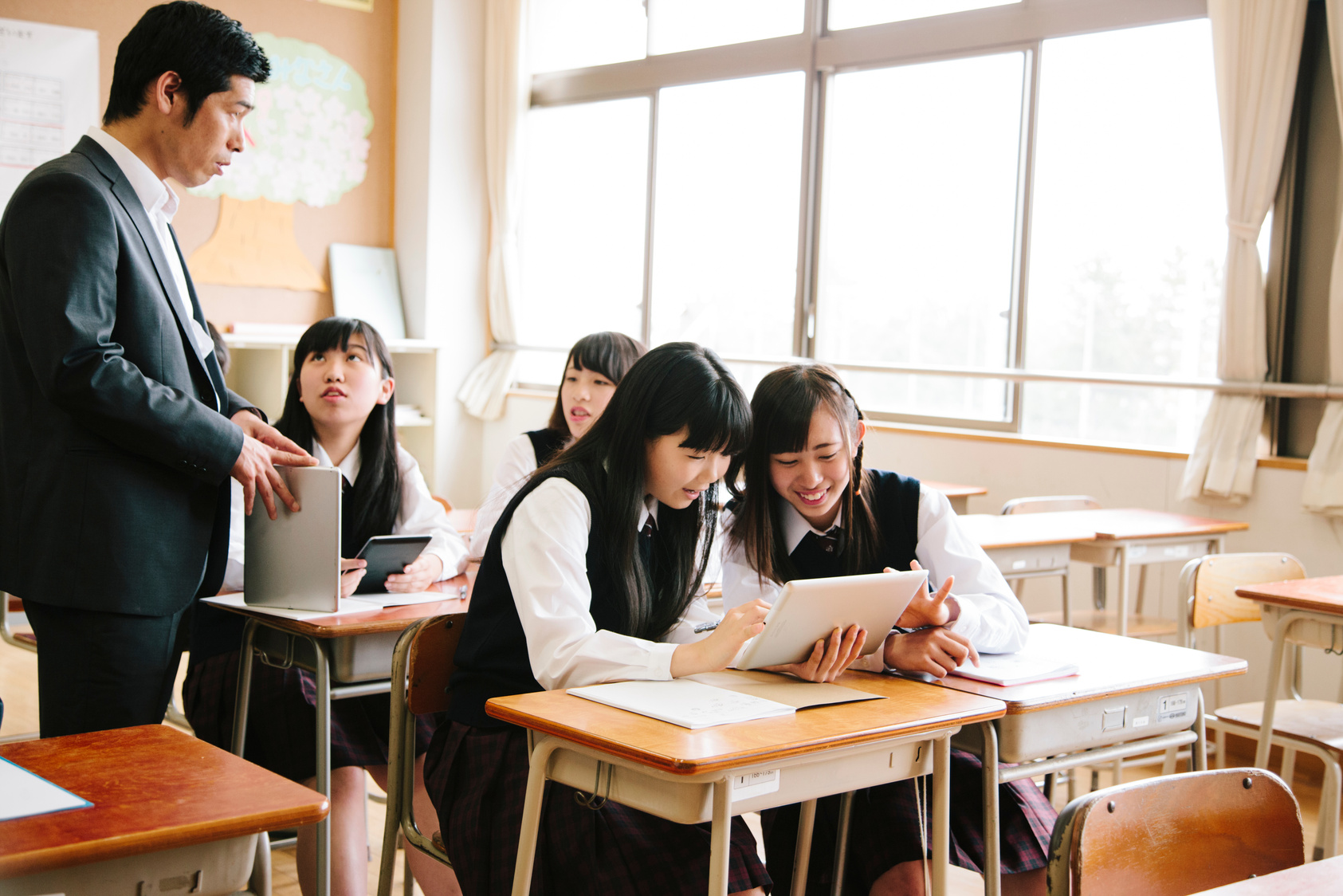 High school class and teacher with tablet computer, Japan