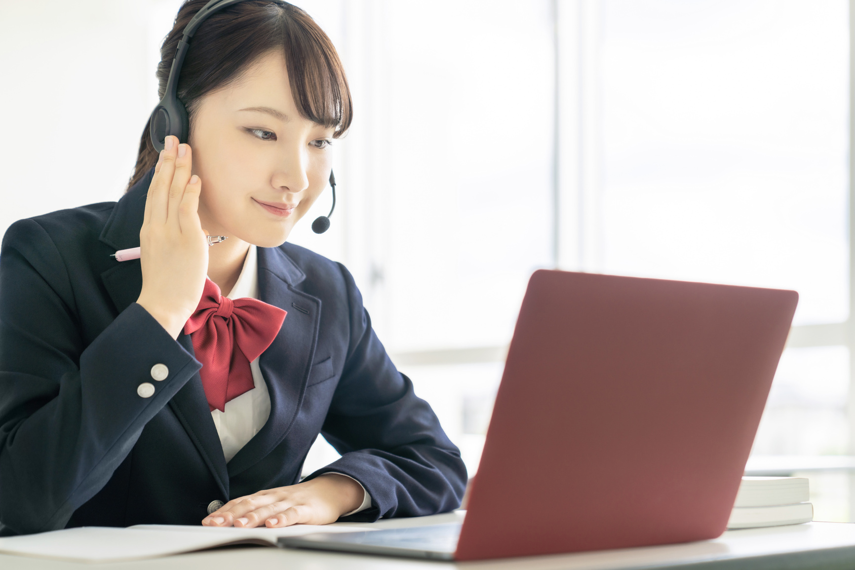 Asian female high school student taking online class.