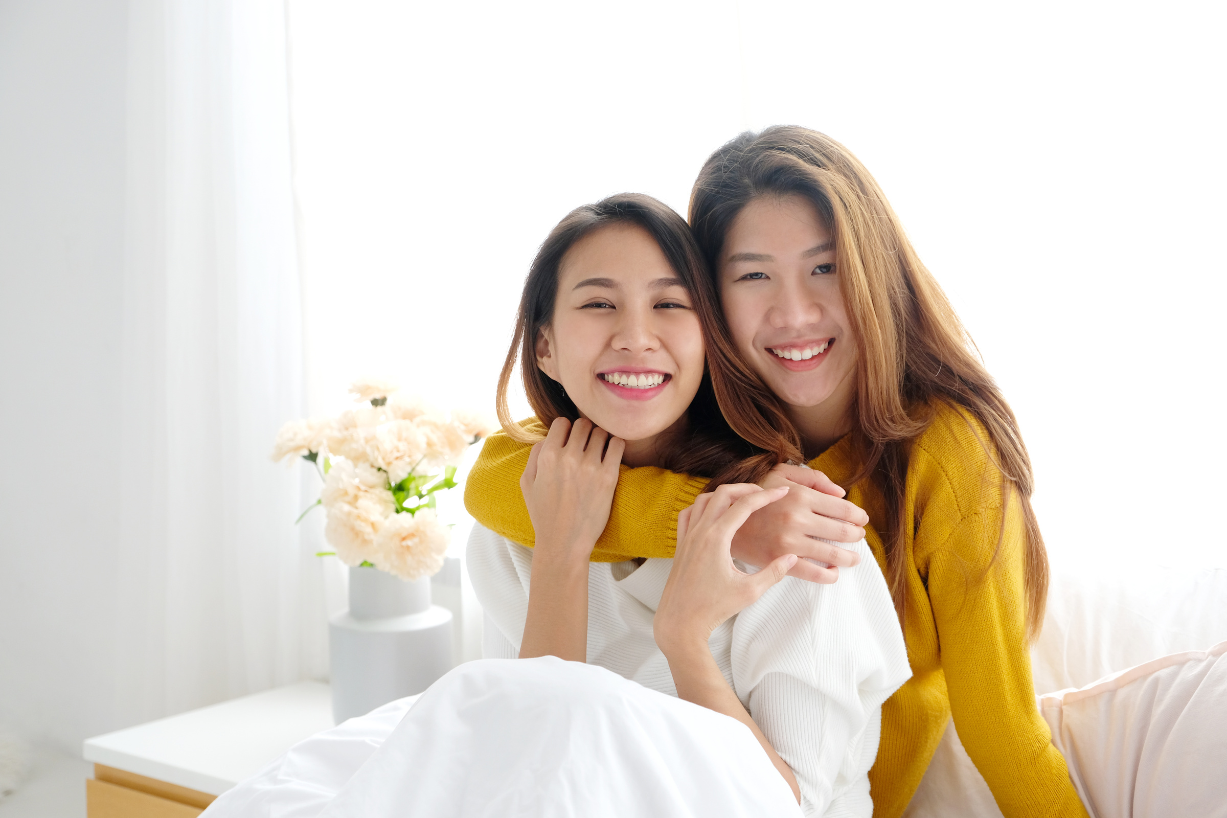 Lesbian Couple Embracing Each Other on the Bed